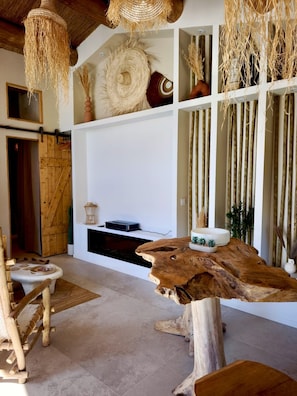 A rustic interior with a wooden dining table, a fireplace, and a hanging woven light fixture. - Lodge des Baronnies II - Les Cabanes de Provence (Plaisians)