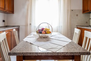 Eine Küche mit Granit-Arbeitsplatte, einem Obstkorb auf dem Tisch und Holzausbau.