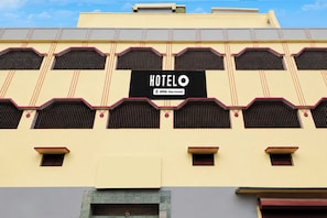A hotel with a sign reading 'HOTEL O YO-Serviced' and a distinctive architectural style with multiple windows and a flat roof. - Super Hotel O Badambadi Bus Terminal (Cuttack)