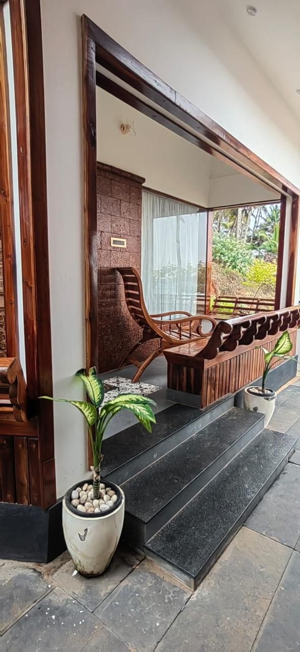 A wooden staircase leading to a covered outdoor seating area with a view of greenery.