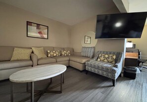 A living room with a sofa, armchair, and a coffee table. - amerivu inn & suites alton (Alton)