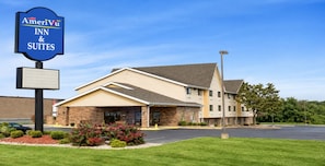 A hotel with a sign for AmeriVu Inn & Suites, featuring a brick facade, a covered entrance, and a parking lot. - amerivu inn & suites alton (Alton)