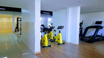 A gym with cardio equipment, including treadmills and stationary bikes, and weightlifting machines.