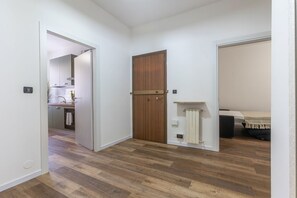 A hallway with wooden flooring, a wooden door, and a radiator. - A bright 96-square-meter apartment, perfect for seven people, located on the first floor of a building without an elevator.The property enjoys an ideal location for exploring the streets of the historic center—with its charming vistas, shops, and local (Ferrara)