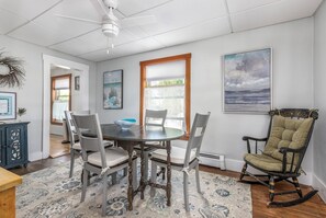 A dining area with a round table, four chairs, a decorative bowl, and a rocking chair. - Perfect spacious and sunsoaked 4-bedroom house near beach in Old Orchard Beach (Old Orchard Beach)