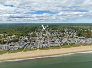 An aerial view of a coastal town with residential buildings, a beach, and a lighthouse. - Perfect spacious and sunsoaked 4-bedroom house near beach in Old Orchard Beach (Old Orchard Beach)