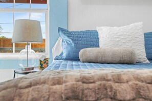 Une chambre à coucher avec un lit, une lampe et une vue sur l’extérieur.