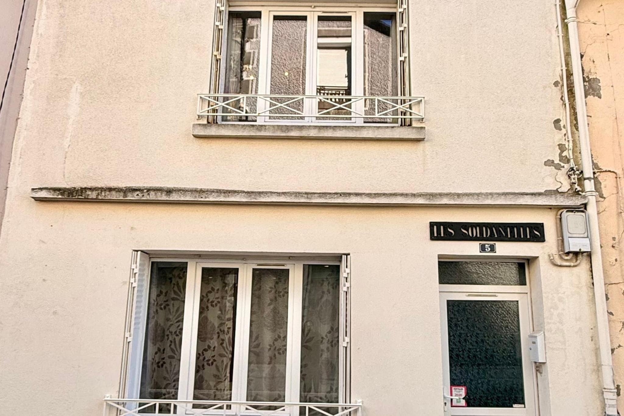 A building with a sign reading 'LES SOLDATTS' and a number '5' above the entrance.