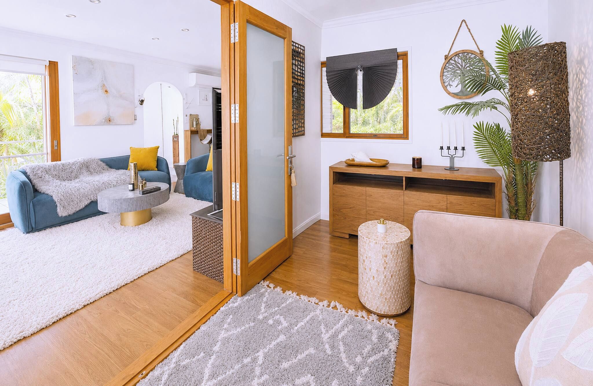 Un salon moderne comprenant un canapé, une table basse et un coin repas avec un buffet en bois.