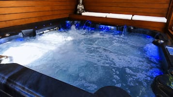 A hot tub with a wooden interior and a Buddha statue.