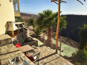 An outdoor patio with a stone table, a chair, and a metal sink. - Country House 'Finca Fani 1 con Estudio' with Sea and Mountain Views, Pool, Wi-Fi, Terrace and Garden (Los Corralillos)