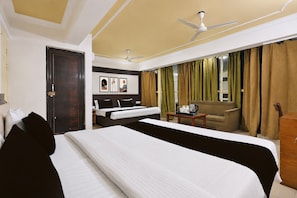 A hotel room with a large bed, a desk with a coffee maker, a sofa, and a view of the outdoors. - Townhouse City Centre Gwalior (Gwalior)