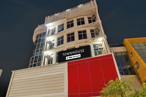 A multi-story building with a sign reading 'TOWNHOUSE' and 'OYO-Serviced'.