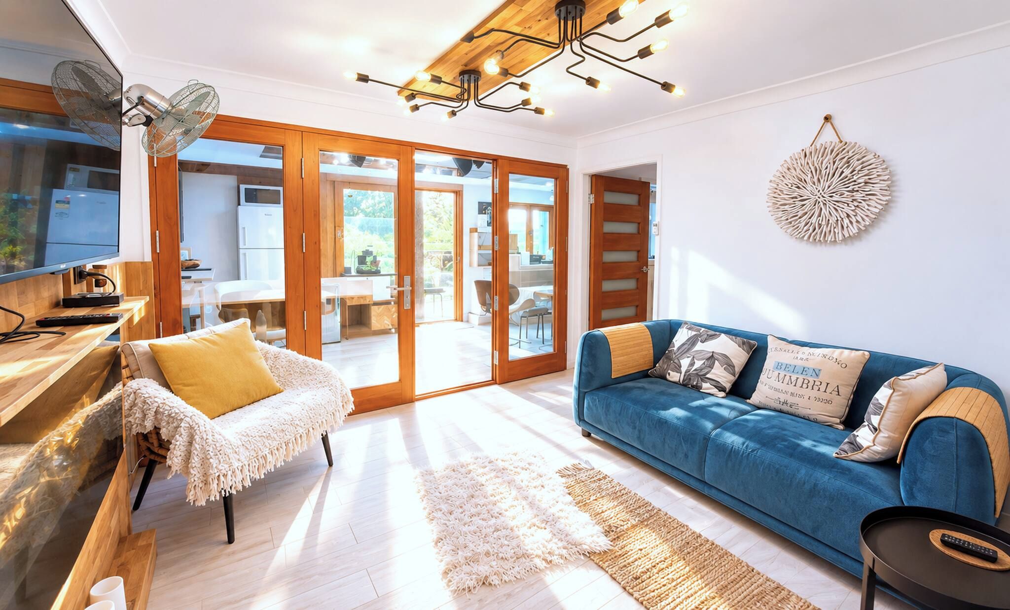 A modern living room with a blue sofa, a white armchair, and a wooden coffee table.