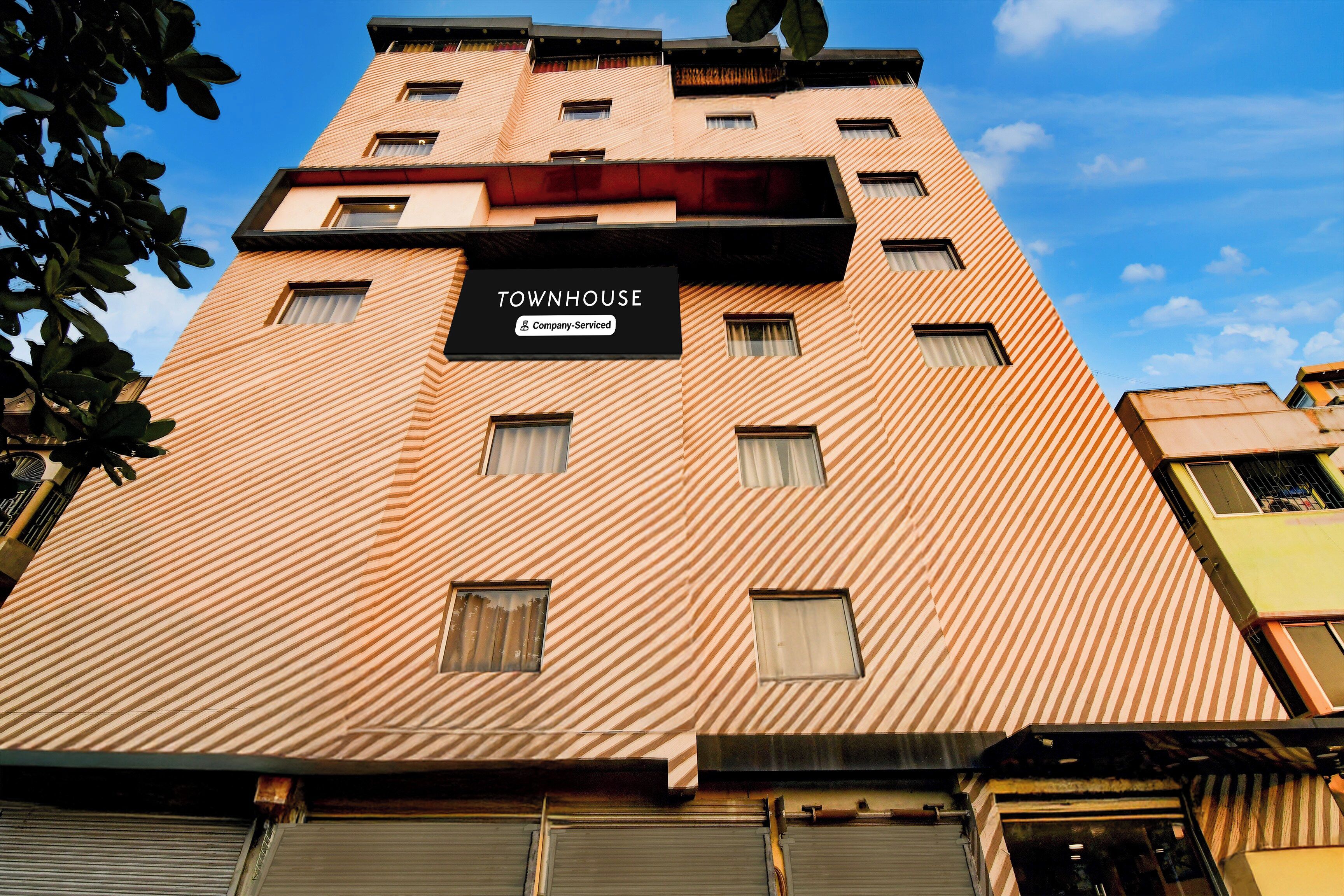 En byggnad med flera våningar, och en skylt som visar texten: ”TOWNHOUSE – företagstjänster”.