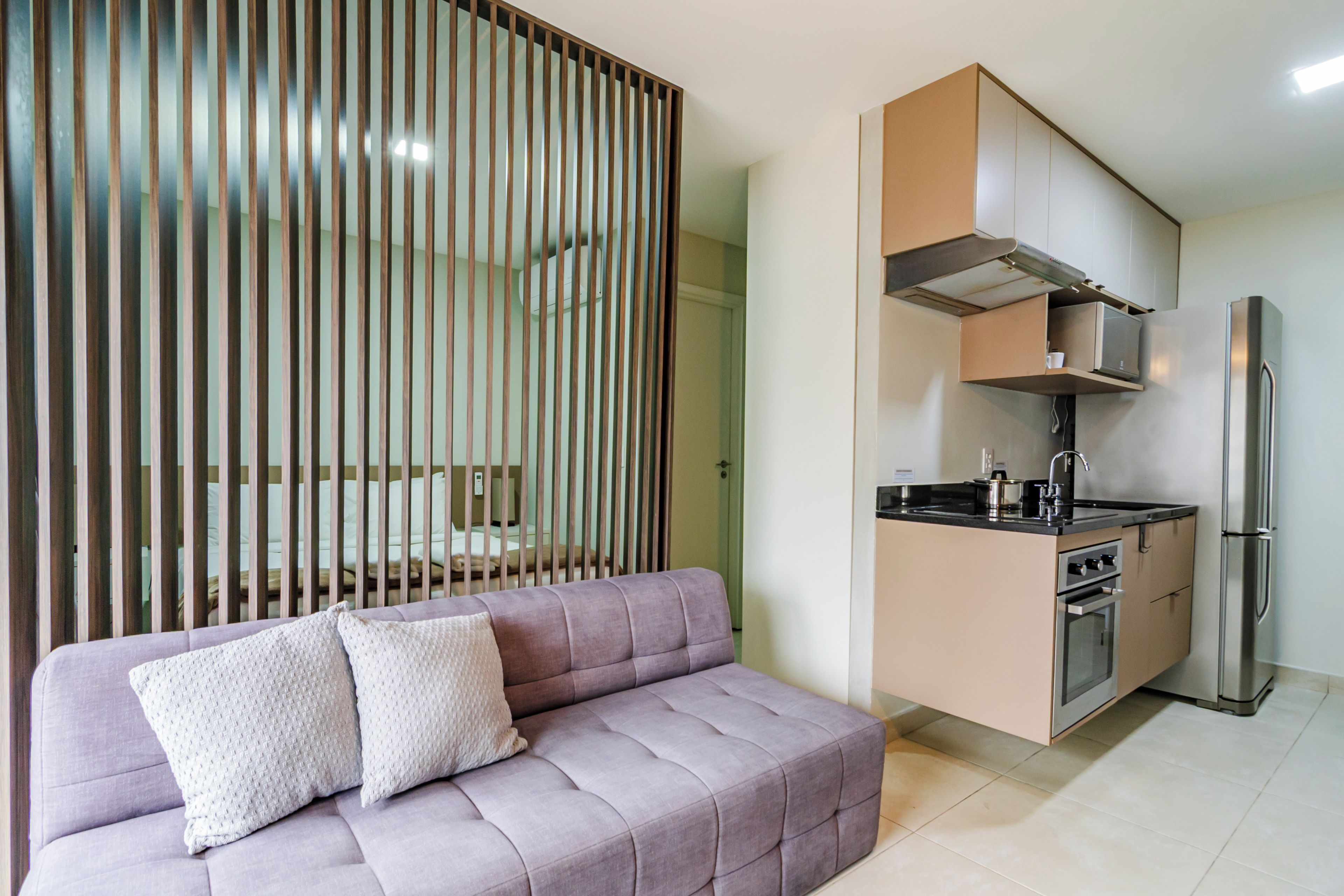 A modern kitchen with a built-in oven, microwave, and stainless steel refrigerator.