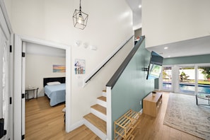 A modern interior with a staircase, a bedroom, and a view of a swimming pool. - Heated Saltwater Pool, Pac-Man Arcade, 2 Putting Greens & Tampa Beach Getaway (Tampa)