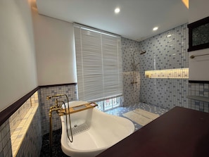 A bathroom with a bathtub, a shower, and a window with blinds. - VESTA BOUTIQUE HOTEL PHU QUOC (Dac Khu Phu Quoc)