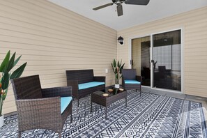 An outdoor patio area with wicker furniture, a ceiling fan, and a patterned floor. - 2/2 Well Maintained quiet retreat in the Village of Duval (The Villages)