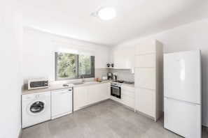 A modern kitchen with a dishwasher, oven, and a built-in washing machine. - Villa Galazio - Three Bedroom Villa, Sleeps 6 (Argaka)