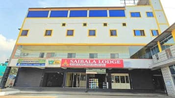 A multi-story building with a sign for 'SAIBALA LODGE' indicating it offers rooms, banquet hall, and party hall.