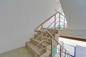 A staircase with metal handrails and a fire exit sign.