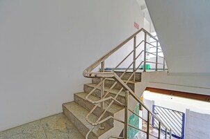 A staircase with metal handrails and a fire exit sign.