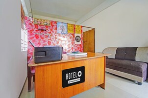 A hotel reception desk with a sign indicating it is company-serviced.