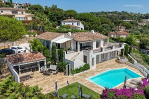Ein Wohnhaus mit Swimmingpool, Sitzgelegenheiten im Freien und Blick auf die umliegende Landschaft.