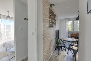 A modern kitchen with a brick wall, a round dining table, and black chairs. - L'Escale Rouennaise - Proche station de Métro (Rouen)