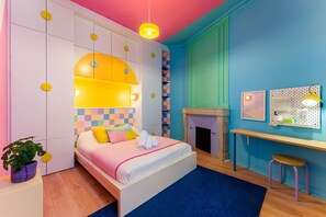 Ein modernes Schlafzimmer mit Bett, Schreibtisch und Kamin.
