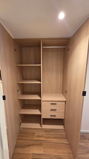 Un dressing avec des étagères et des tiroirs en bois.