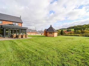 A residential property with a large lawn, a wooden cabin, and a modern house with large windows. - Hanbury House (Ross-on-Wye)