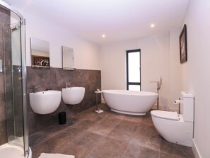 A modern bathroom with a glass-enclosed shower, three sinks, a freestanding bathtub, and a toilet. - Hanbury House (Ross-on-Wye)