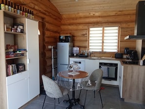 Une cuisine de taille réduite comprenant une table à manger, des chaises et un réfrigérateur.