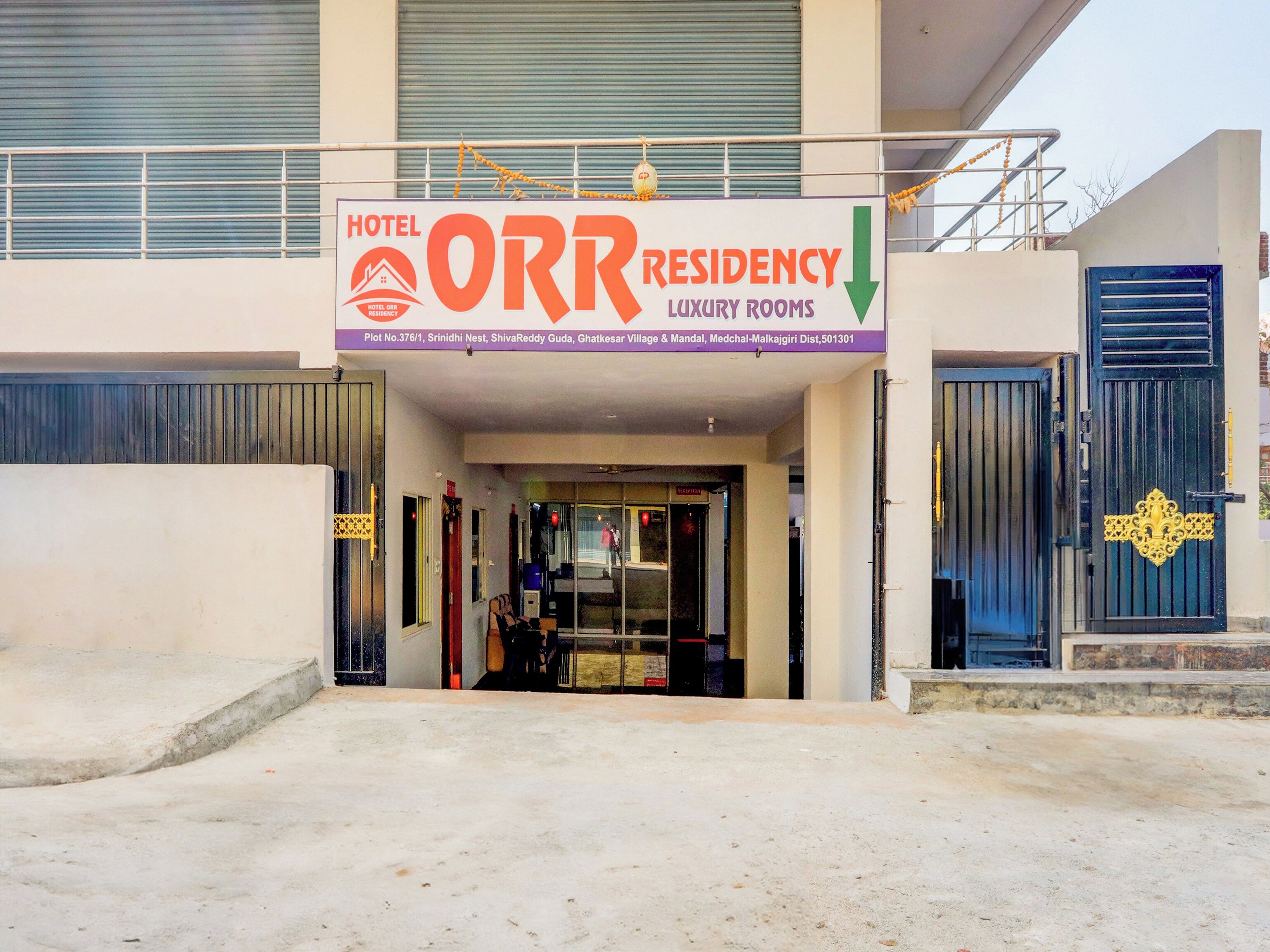 A hotel entrance with a sign indicating 'HOTEL ORR RESIDENCY LUXURY ROOMS.'
