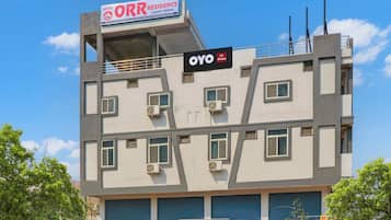 Um edifício com vários andares, com placas indicando 'Hotel ORR Residency Luxury Rooms' e 'OYO Hotel'.