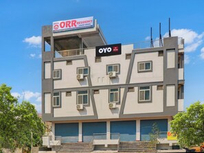 Un edifici de diverses plantes amb cartells que indiquen 'Hotel ORR Residency Luxury Rooms' i 'OYO Hotel'.