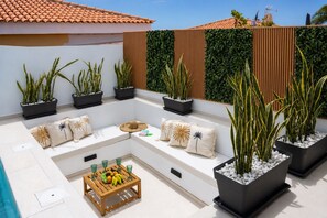 A rooftop patio with a seating area, potted plants, and a fruit bowl. - New Listing (Callao Salvaje)