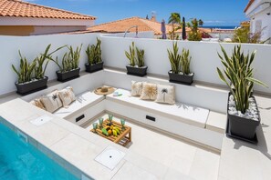 A rooftop terrace with a pool, potted plants, seating, and a fruit tray. - New Listing (Callao Salvaje)