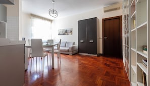Ein modernes Wohnzimmer mit Essbereich, einer Couch, einem Couchtisch und einem großen Kleiderschrank.