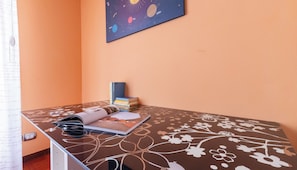 Ein Arbeitszimmer mit Schreibtisch, Büchern, einem Globus und Wandkunst mit Planetenmotiven.