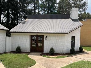 A single-story building with a gabled roof, a front door, and a small window. - Golf Club Hideaway (Oxford)