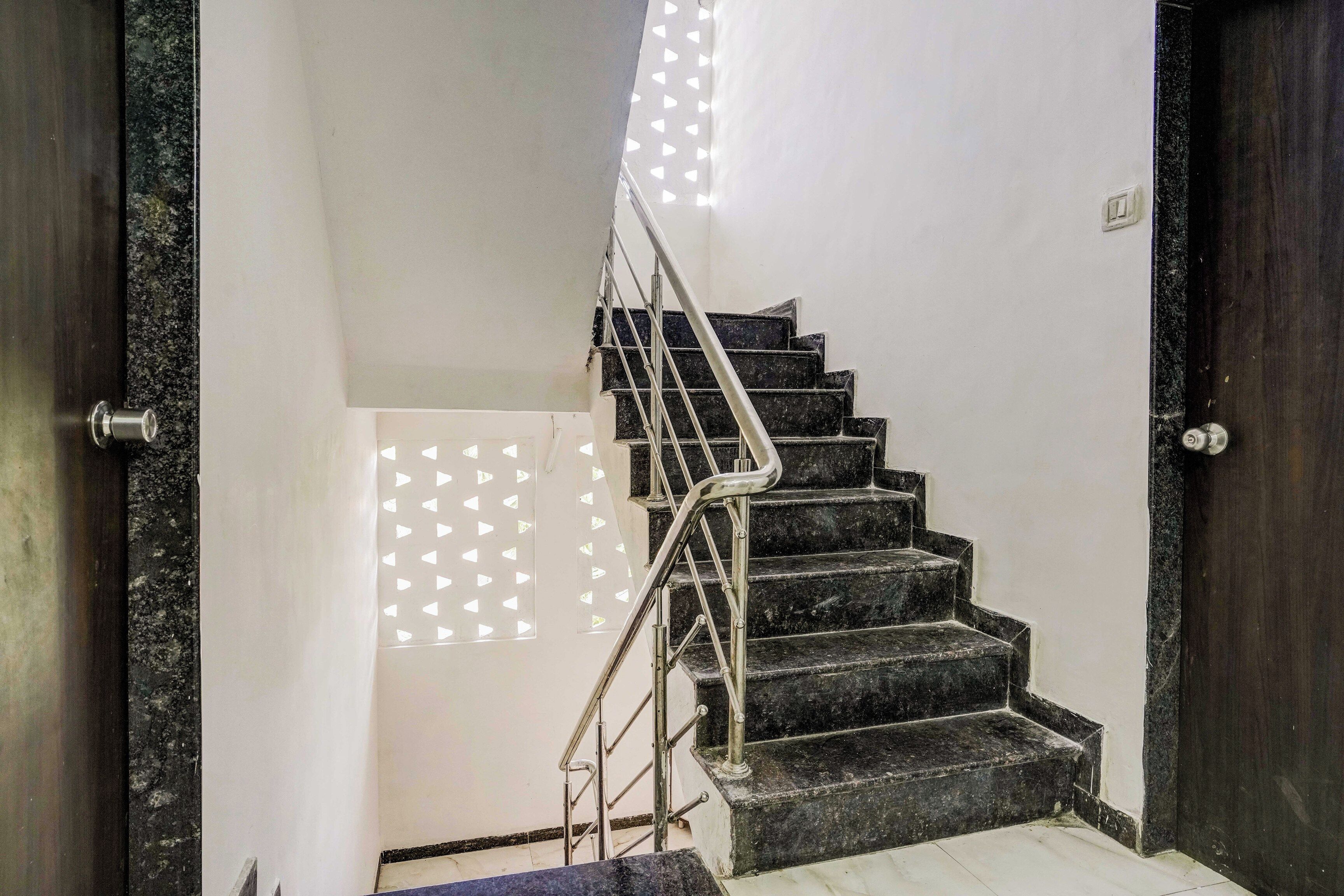 A staircase with a metal handrail leading to a landing.