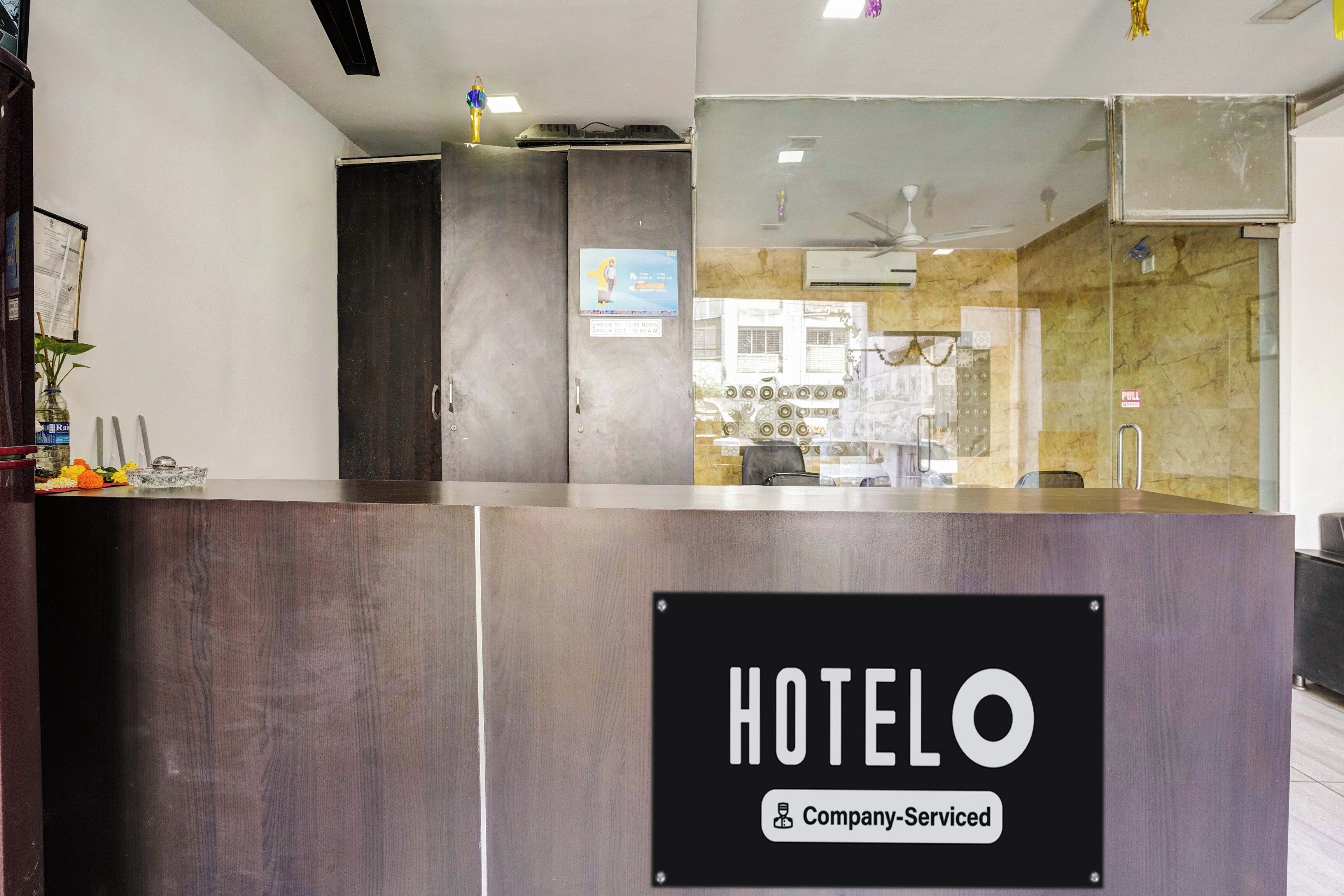 Una mesa de recepción con un cartel que dice 'HOTELO Company-Serviced'.
