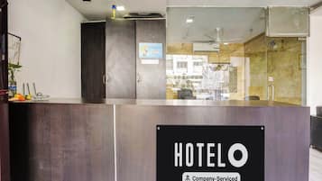 Una mesa de recepción con un cartel que dice 'HOTELO Company-Serviced'.