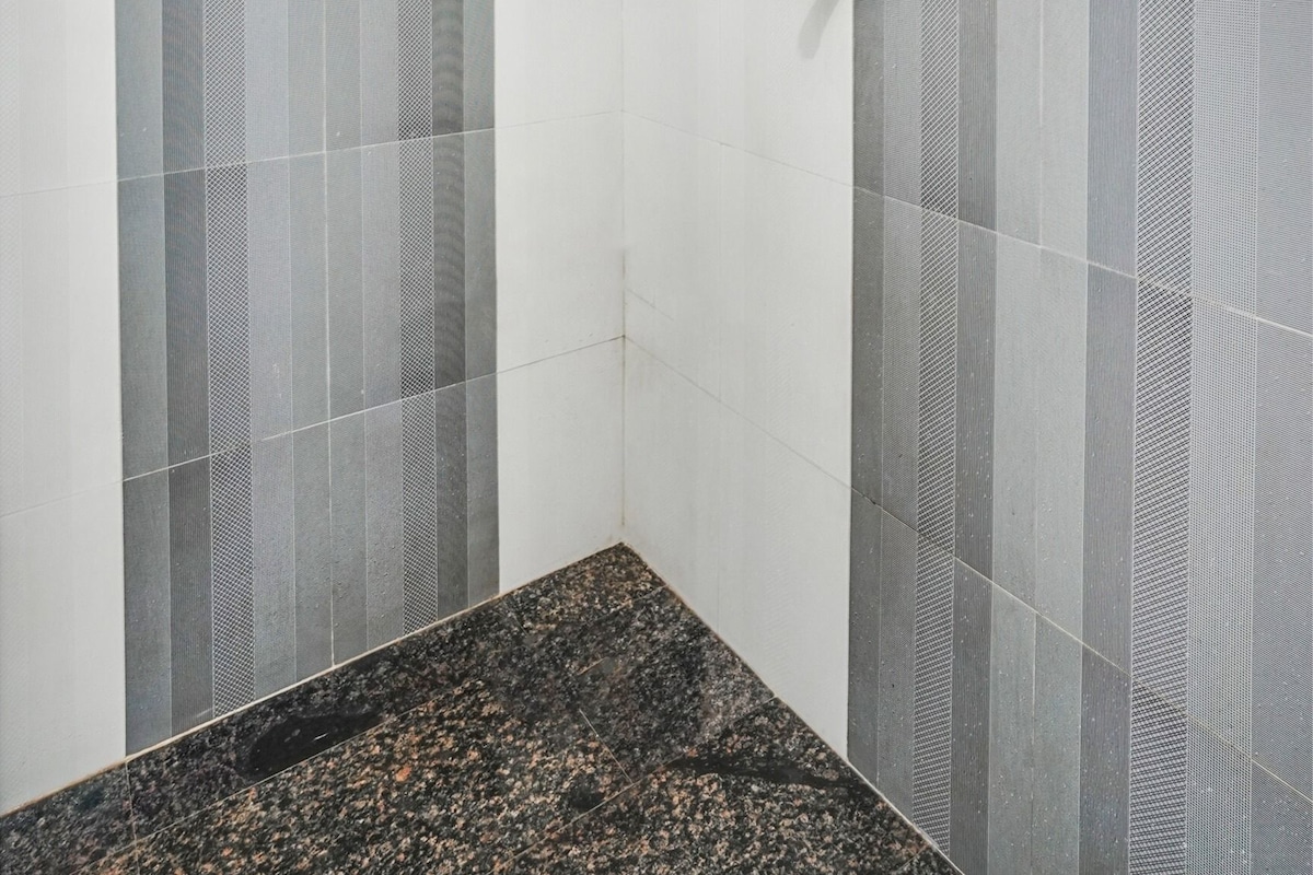 A bathroom with a shower, a towel rack, and a sink.