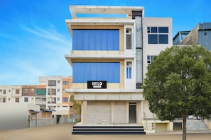 A multi-story hotel with a prominent 'HOTEL' sign, featuring a modern design with a flat roof and large windows. - Hotel O Radhaswami Nagar (Jaipur)