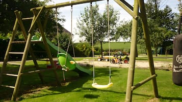 Een speelplaats met een schommel en een glijbaan.