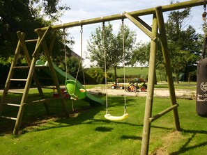 A playground with a swing set and a slide.